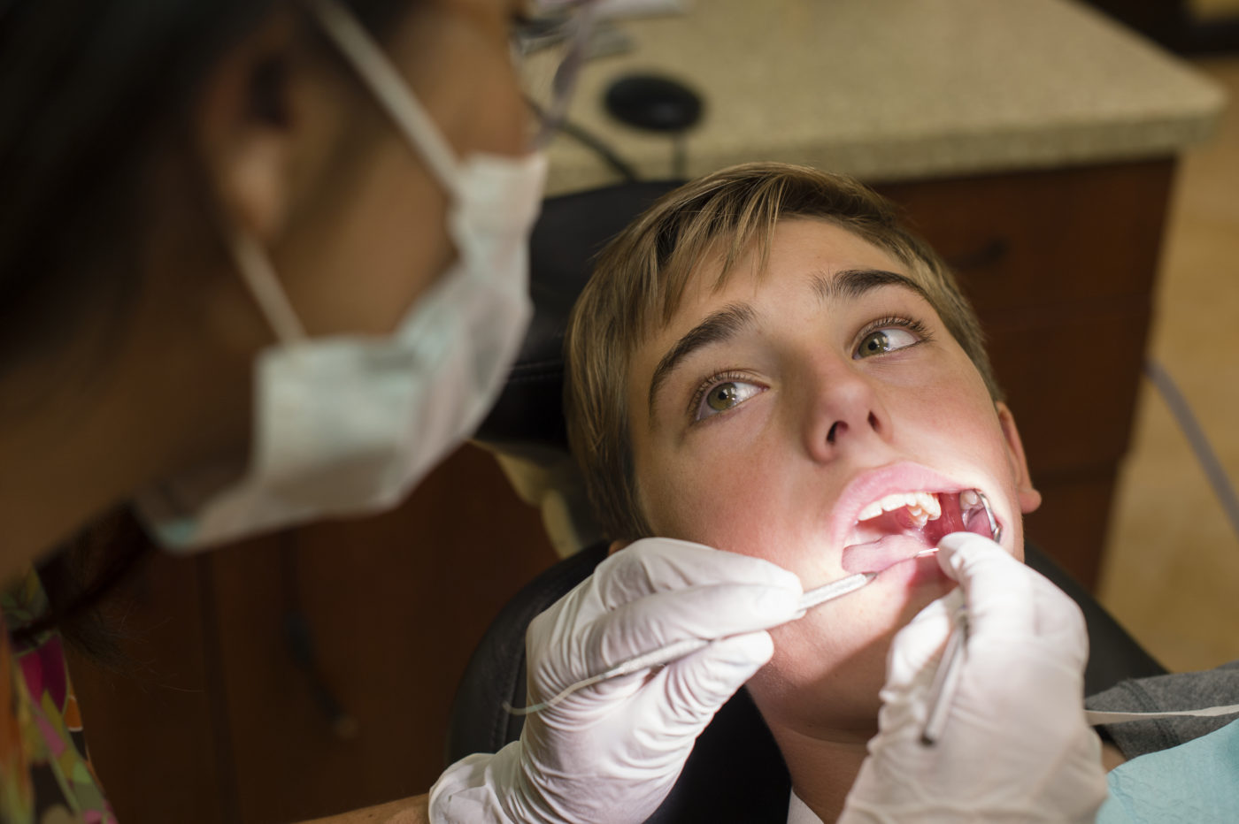A Bupa Dental Care dentist examining dental patient's mouth.