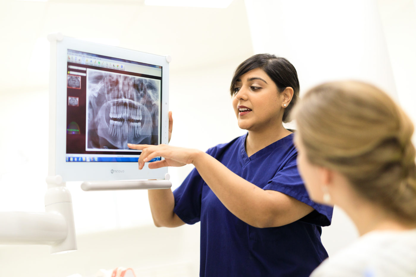 A Bupa Dental Care dentist explains a teeth x-ray to a patient.